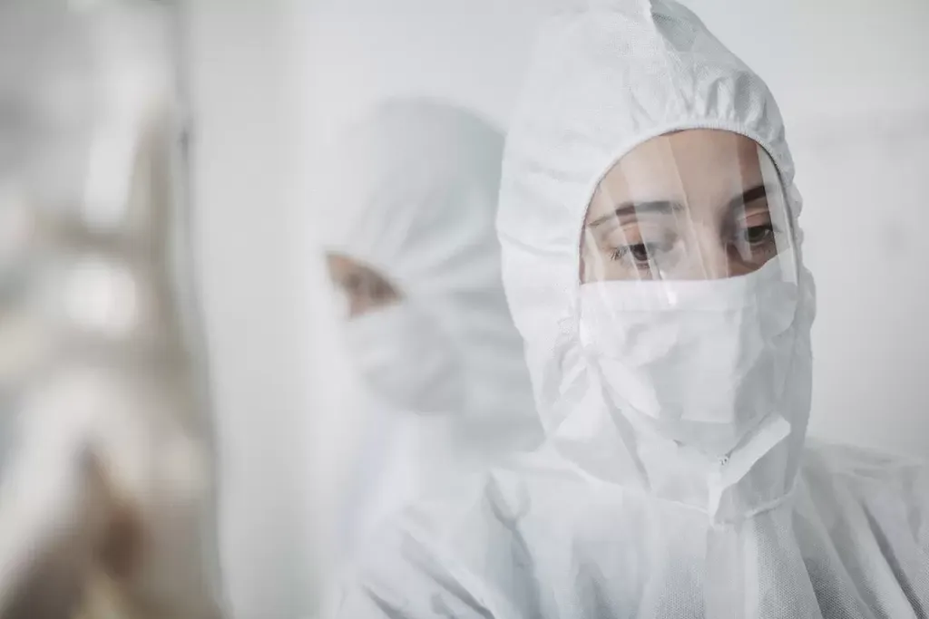 製薬業界、マスクと白い防護服を着た女性薬剤師