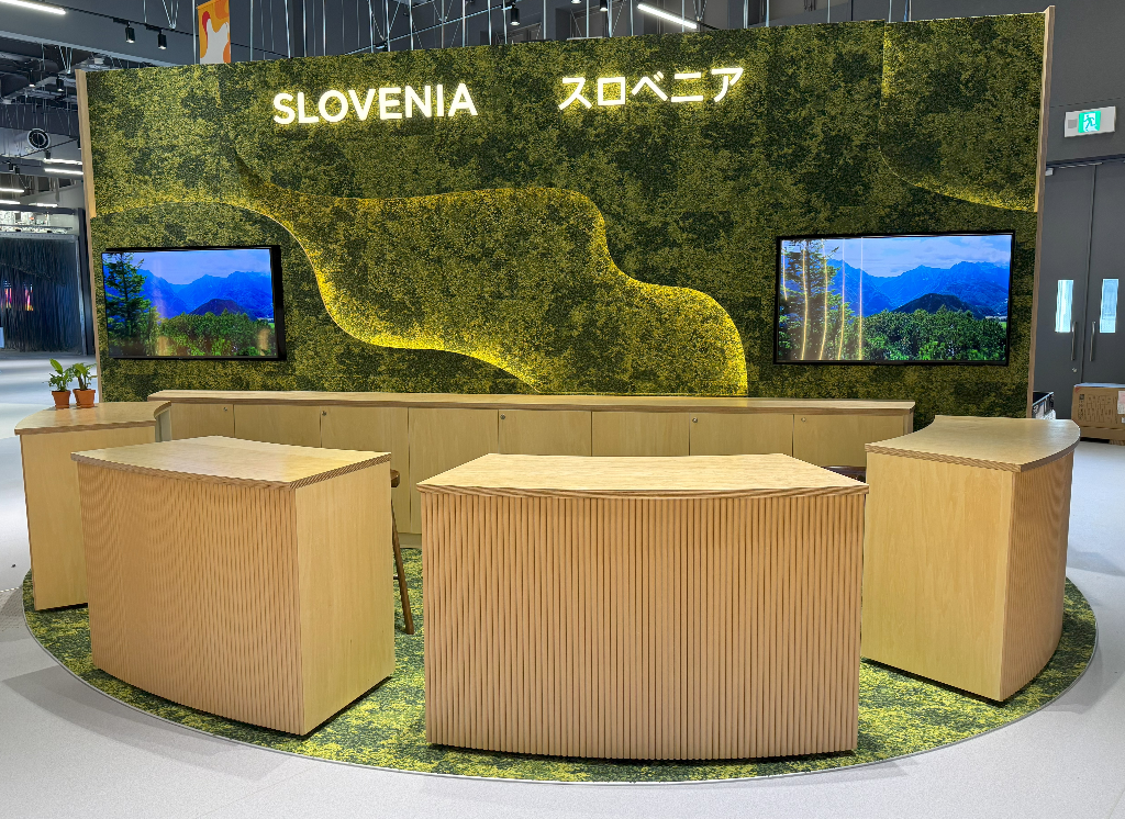 Slovesnki paviljo, na sliki je lesen info pult v ozadju pano z dvema zaslonoma 